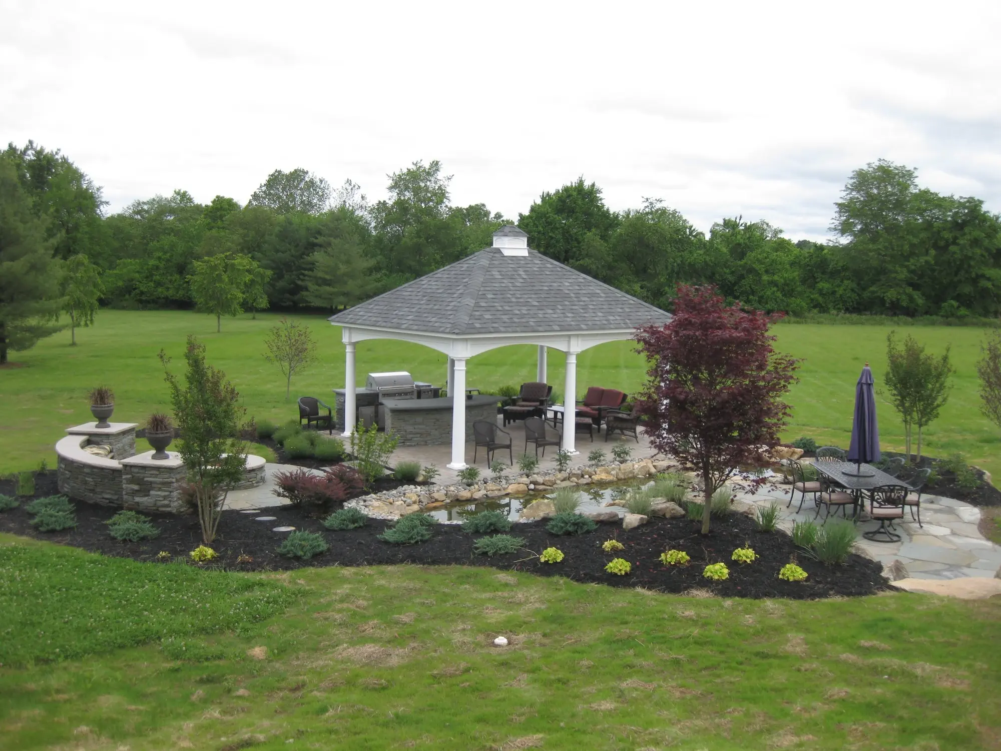 Large estate backyard with gazebo, koi pond, and stone walls
