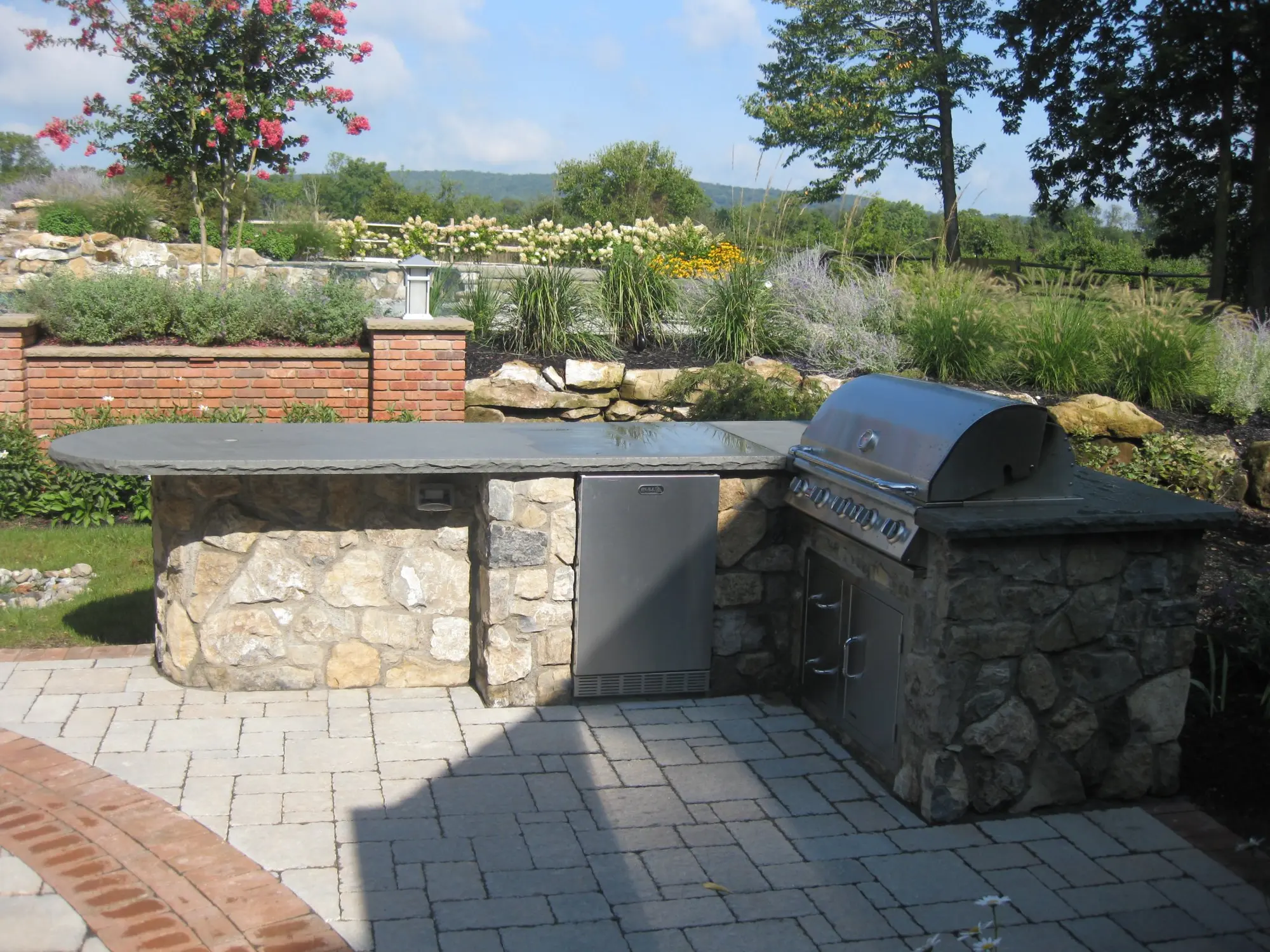 Rustic stone fire pit with natural stone seating wall